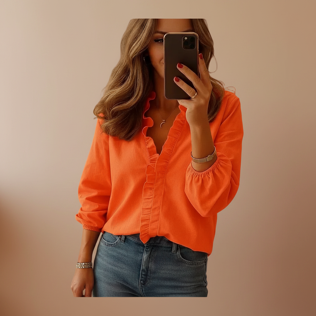 Ruffled blouse shown from the front on a plain backdrop